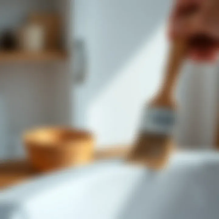 A close-up of a brush applying paint on a bathroom cabinet surface