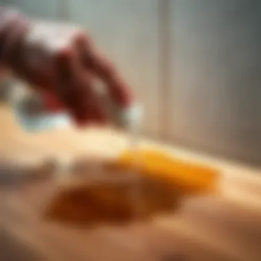 Hand applying a cleaning solution to an oil stain